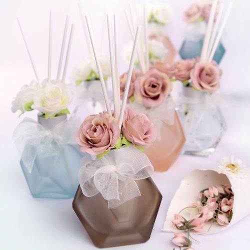 Bottiglia per profumo color legno e rose rosa